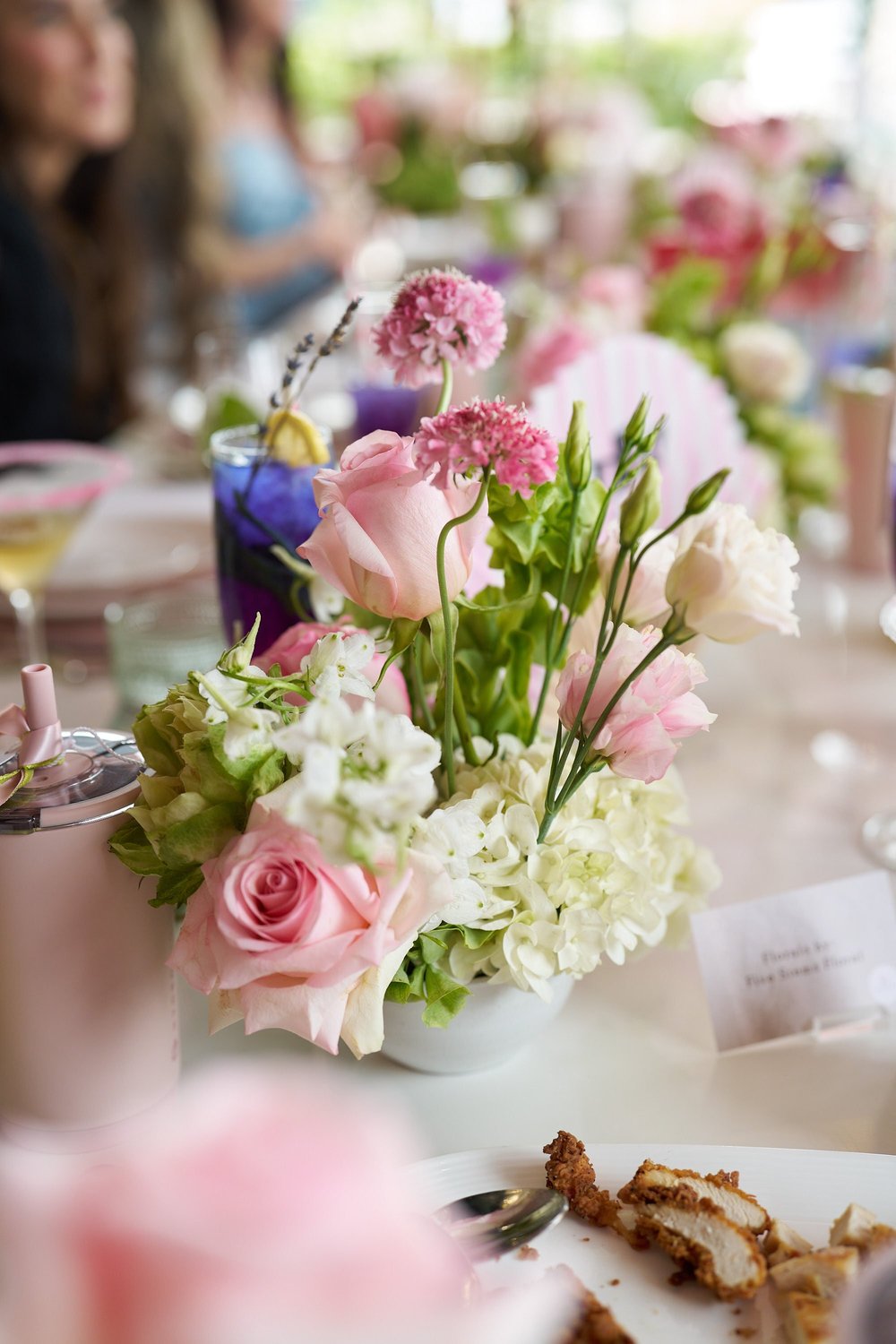 Pink rose and hydrangea centerpiece on a set table